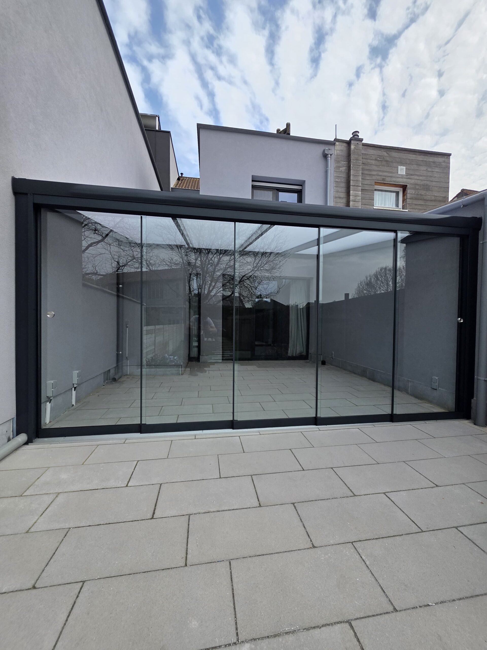 Aluminium aanbouw overkapping met glazen schuifwanden aan woning – D&C Terrasoverkappingen